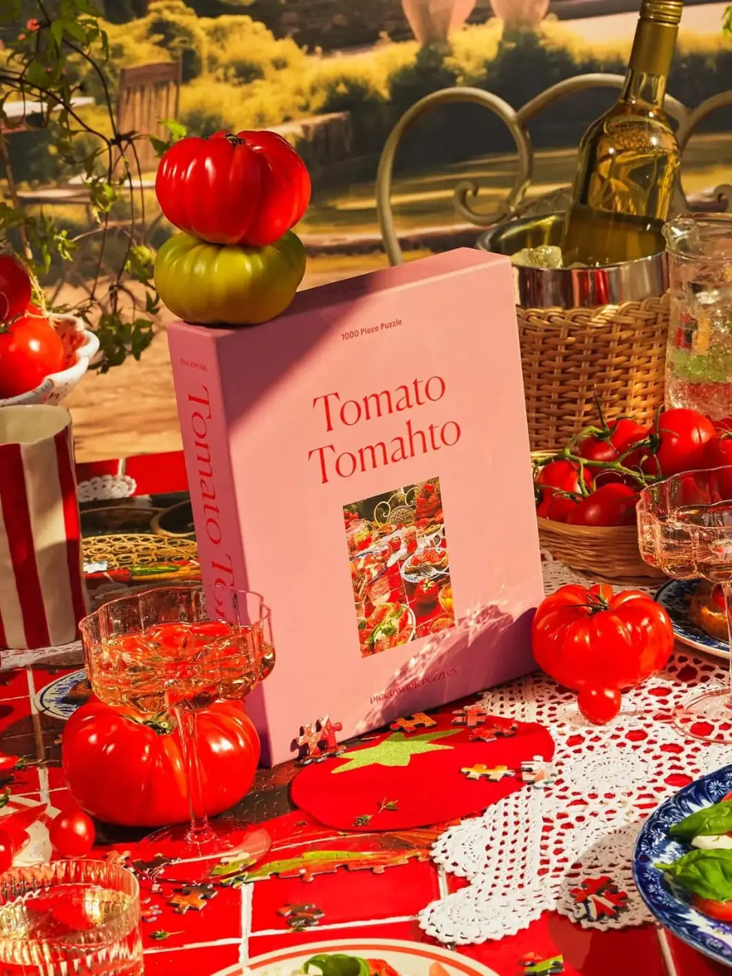 Table setting with 'Tomato Tomahto' puzzle from Piecework Puzzles, tomatoes, and glasses outdoors | Twentyseven Toronto