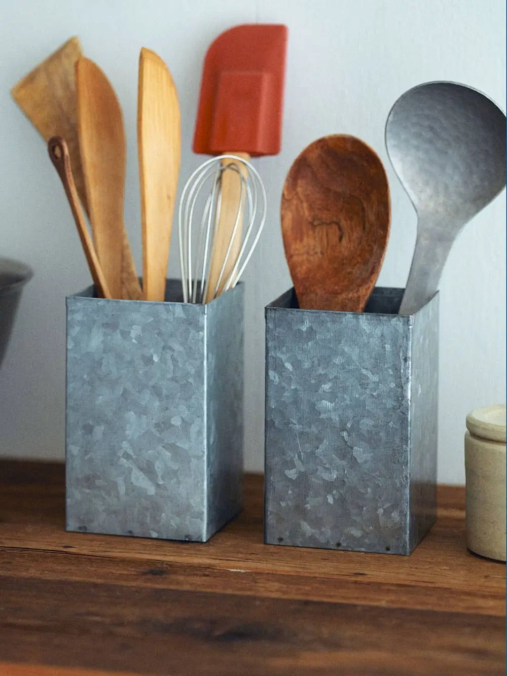 Two galvanized steel Fog Linen Work Tool Stand containers are shown on a wooden shelf, neatly organizing a variety of wooden and silicone kitchen utensils | Twentyseven Toronto