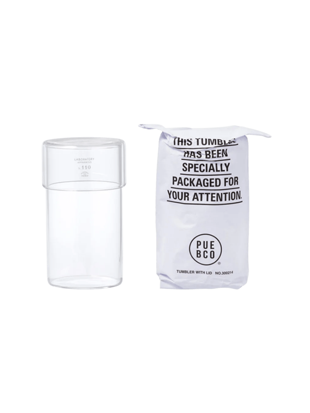Clear glass Tumbler With Lid from Puebco standing beside its signature stamped paper packaging | Twentyseven Toronto