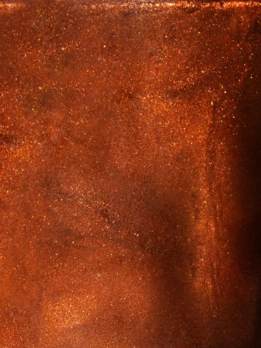 A close-up texture shot showing the shimmering, micro-glitter surface of the copper-toned BKIND Nail Polish in Une Cenne formula | Twentyseven Toronto