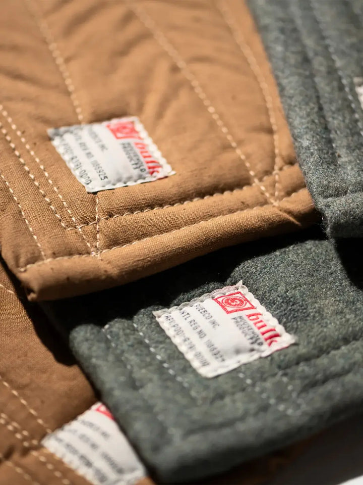 A close-up shot shows the contrasting textures and clean edge stitching on overlapping tan and grey versions of the Vintage Bivouac Trivet from Puebco | Twentyseven Toronto