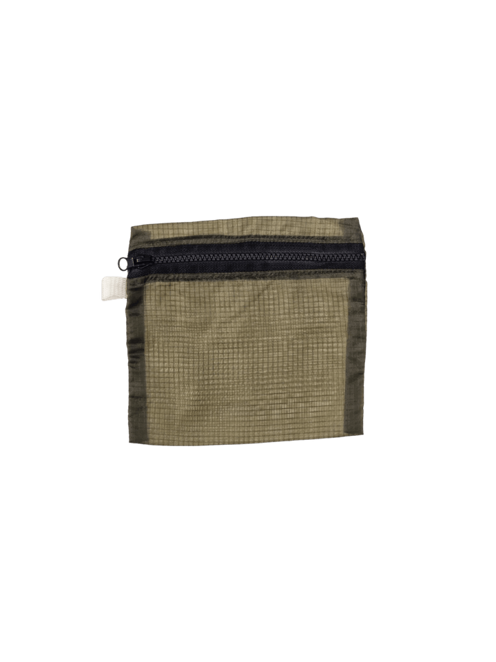 An olive green Vintage Parachute Light Pouch Medium from Puebco is shown flat, showcasing its semi-transparent fabric, top zipper, and small stitched branding detail near the bottom | Twentyseven Toronto