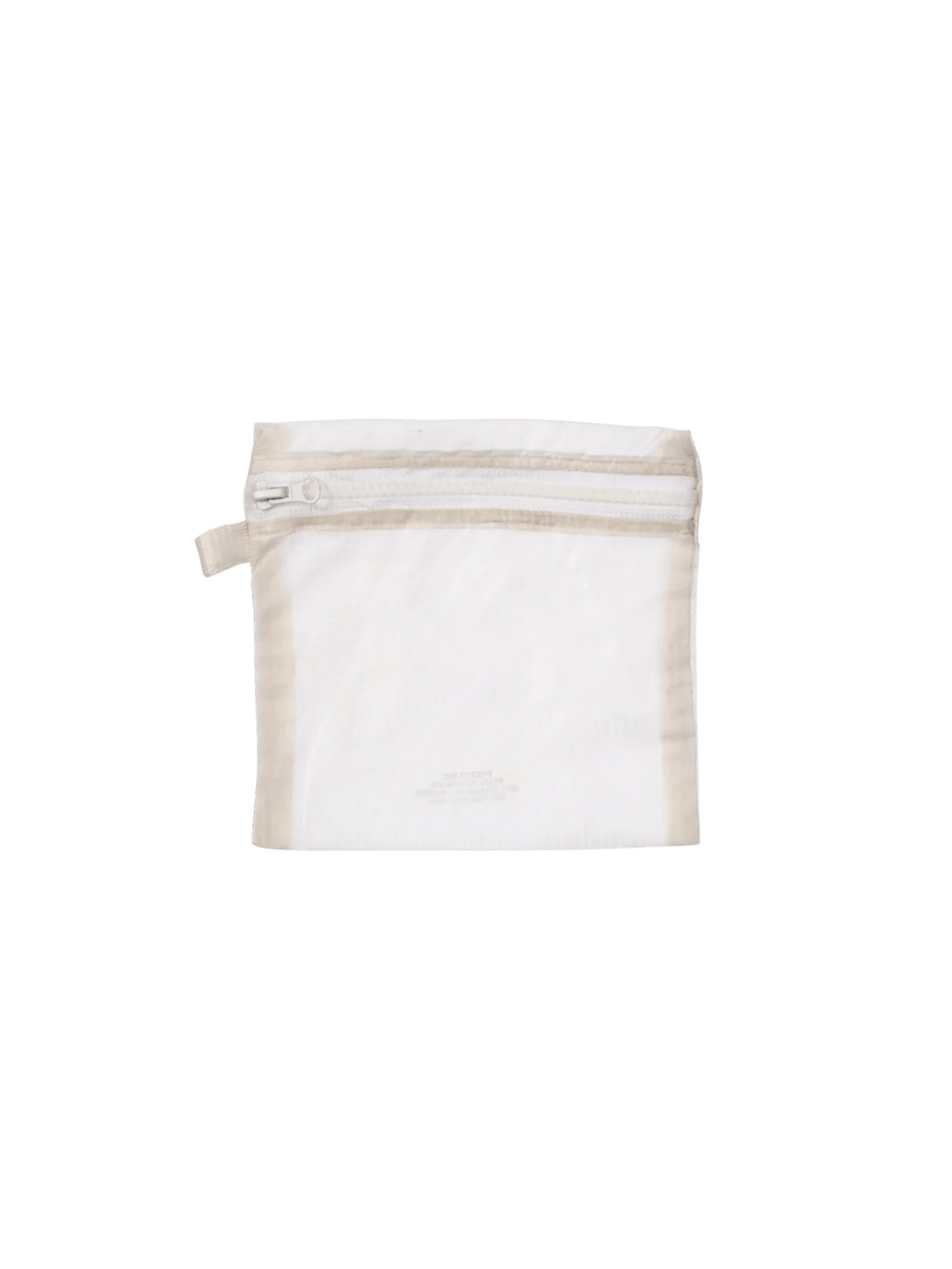 A white Vintage Parachute Light Pouch Medium from Puebco is shown flat, showcasing its semi-transparent white fabric, top zipper, and small stitched branding detail near the bottom | Twentyseven Toronto