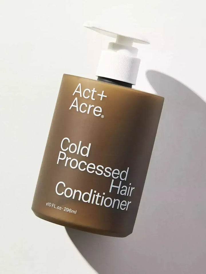 Brown bottle of Act+Acre Cold Processed Hair Conditioner on a light background | Twentyseven Toronto