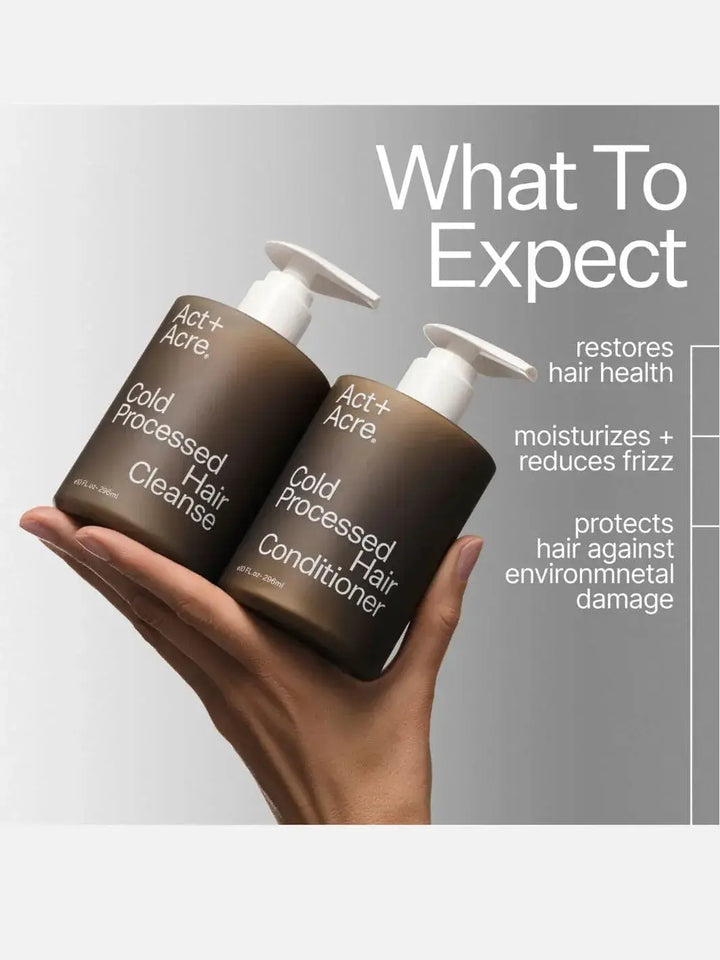 Two 296ml bottles of Act+Acre hair care products held in a hand with text detailing benefits on a gray background | Twentyseven Toronto