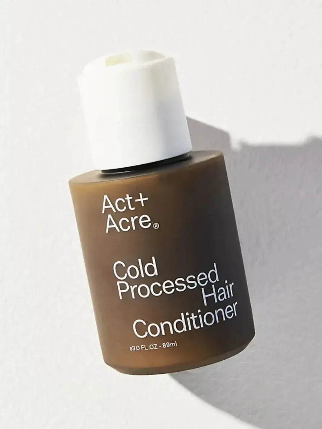 Travel size 89ml Act+Acre Cold Processed Hair Conditioner bottle on a light background | Twentyseven Toronto