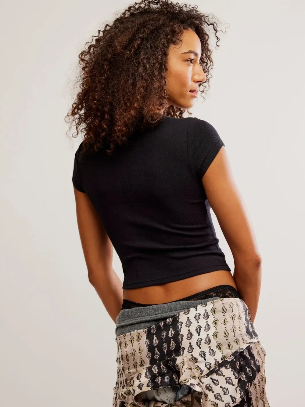 A rear view showcases the straight, clean hemline and snug fit of the Free People Wait A Minute Baby Tee in Anthracite across the back | Twentyseven Toronto