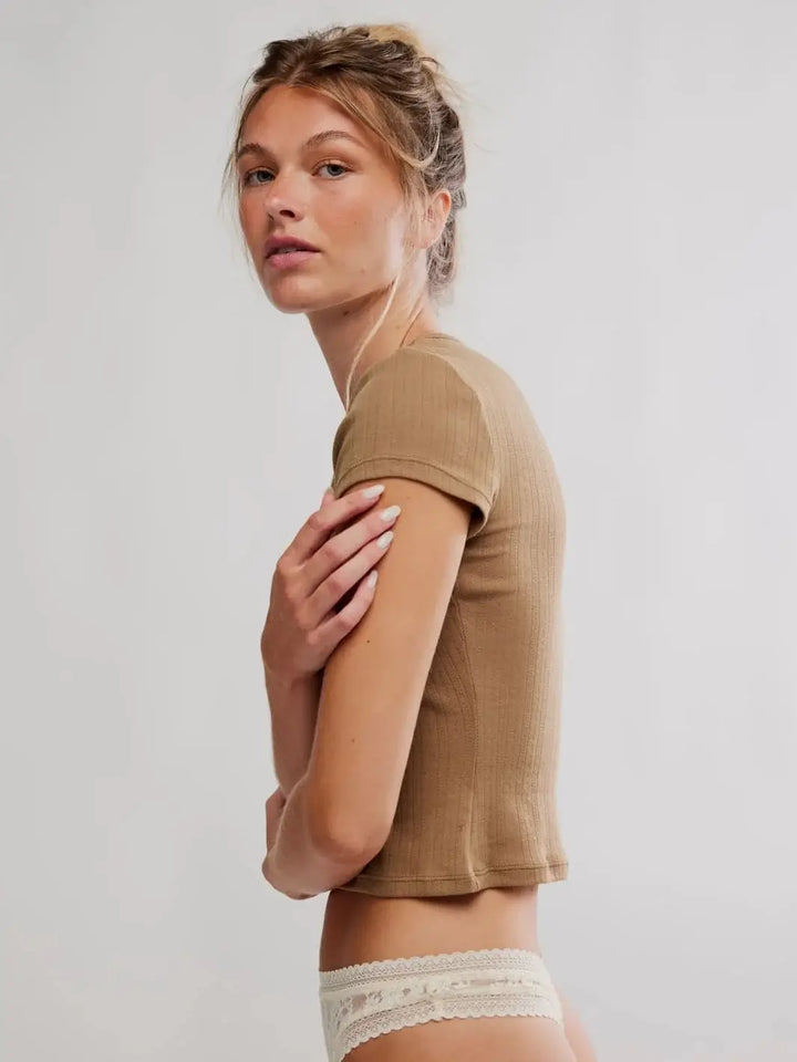 A side profile view displays the short cap sleeves and slightly cropped length of the Free People Wait A Minute Baby Tee in Antique Bronze worn with lace underwear | Twentyseven Toronto