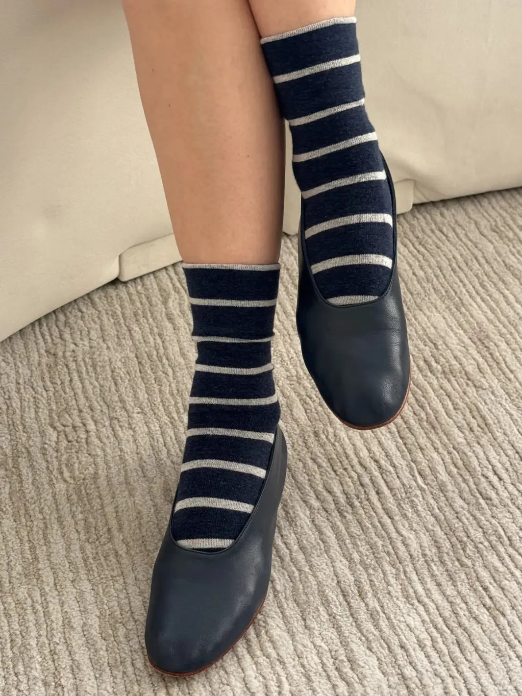 A close-up view shows a person styling the striped Wally Socks in Marine from Le Bon Shoppe with classic navy blue leather ballet flats | Twentyseven Toronto