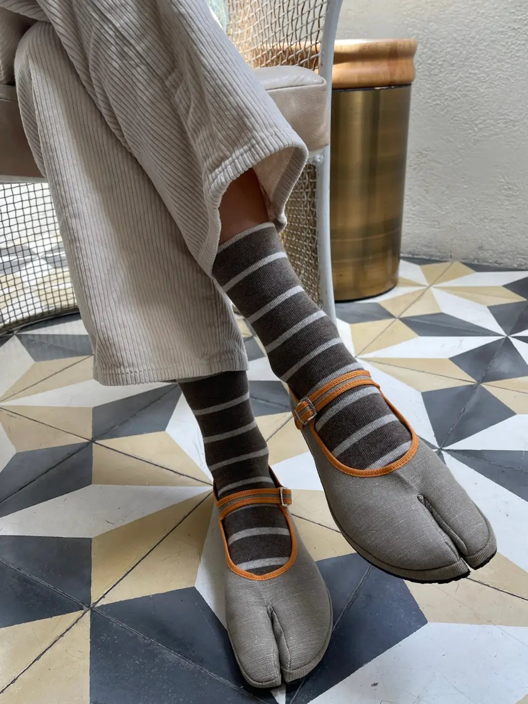 A person wears the striped Wally Socks in Mocha from Le Bon Shoppe paired with unique gray and orange split-toe tabi Mary Jane shoes | Twentyseven Toronto