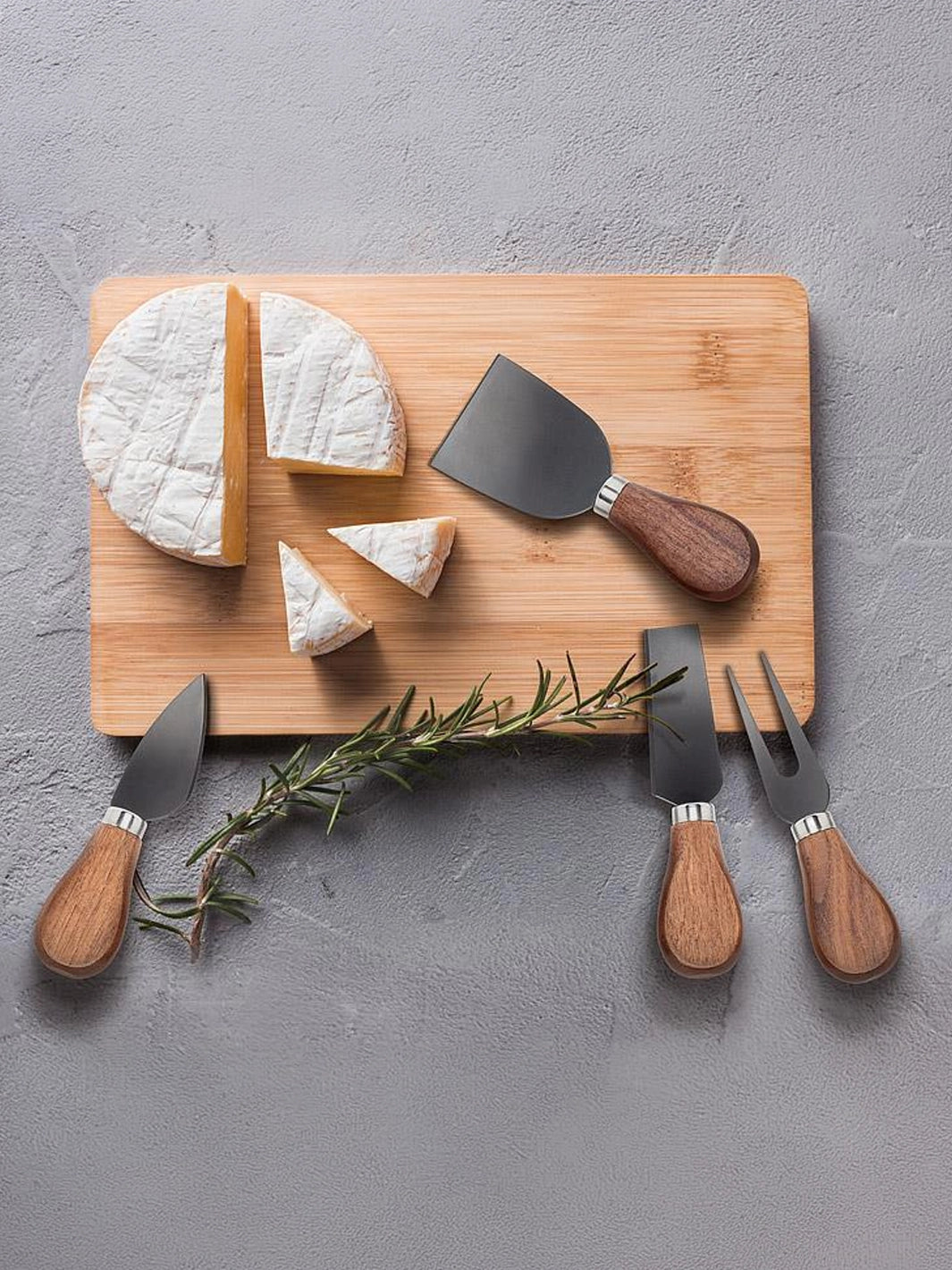 Walnut handled cheese knives styled with soft cheese and rosemary on a serving board | Twentyseven Toronto