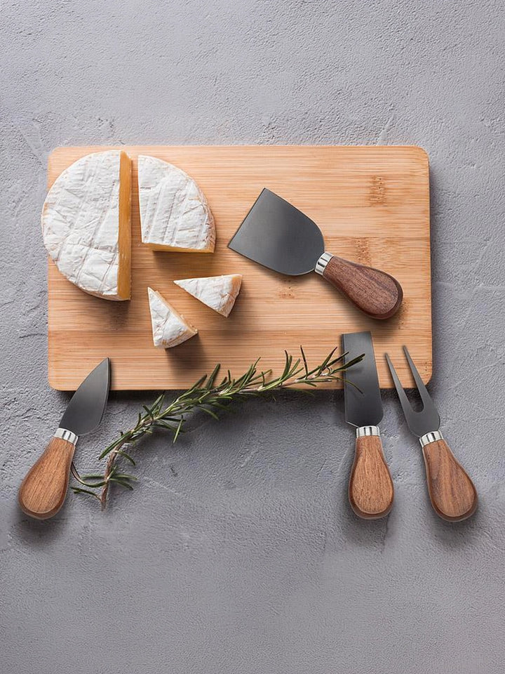 Walnut handled cheese knives styled with soft cheese and rosemary on a serving board | Twentyseven Toronto