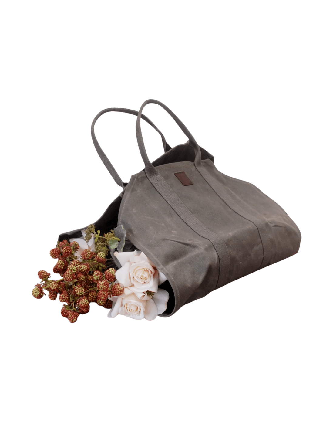 An olive green Waxed Canvas Log Flower Holder from Earth and Nest filled with fresh white roses and flowers on a transparent background | Twentyseven Toronto