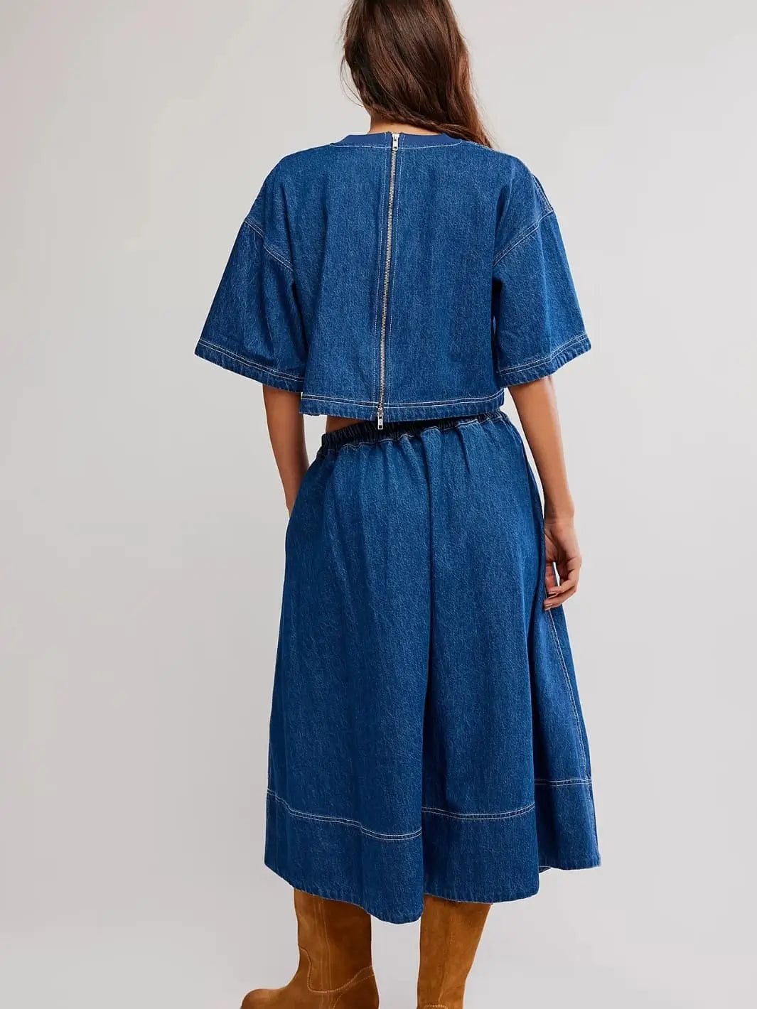 A direct rear view highlights the full-length exposed zipper on the back of the cropped top and the gathered elastic waistband of the Free People Westley Denim Skirt Set in Deep Sea Wash | Twentyseven Toronto