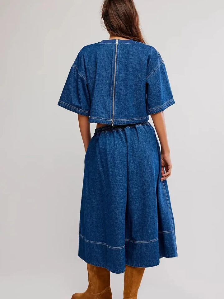 A direct rear view highlights the full-length exposed zipper on the back of the cropped top and the gathered elastic waistband of the Free People Westley Denim Skirt Set in Deep Sea Wash | Twentyseven Toronto