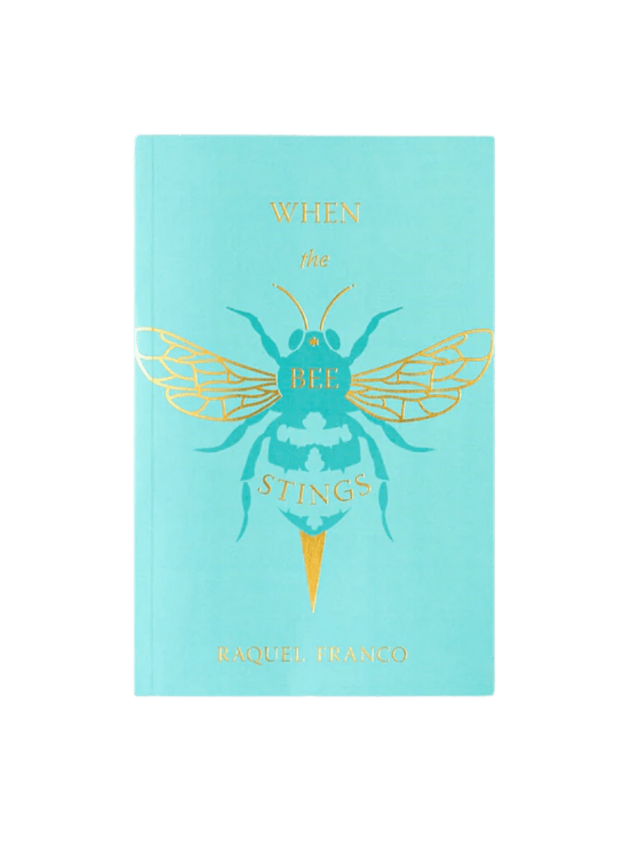 Front cover of When The Bee Stings by Raquel Franco features a turquoise background adorned with an intricate, gold foil illustration of a honeybee | Twentyseven Toronto