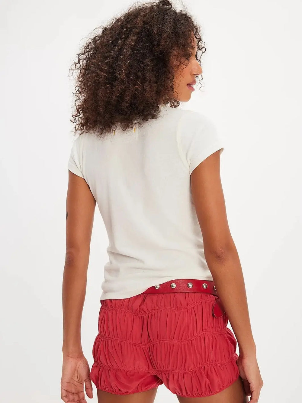 A rear view captures the clean back panel, capped sleeves, and fitted silhouette of the Free People Wild Country Tee - Colorado Combo styled with textured red shorts | Twentyseven Toronto
