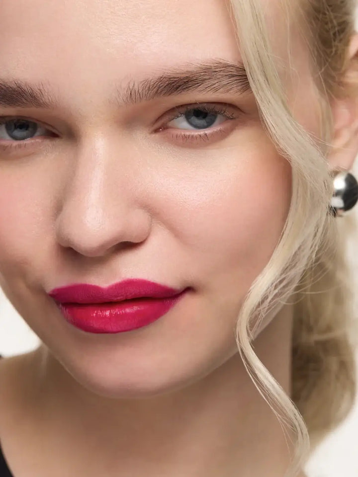 A fair-skinned blonde model wearing the high-pigment, cool-toned magenta of the Wonderskin WONDER BLADING Lip Stain Masque in Neon Rose | Twentyseven Toronto
