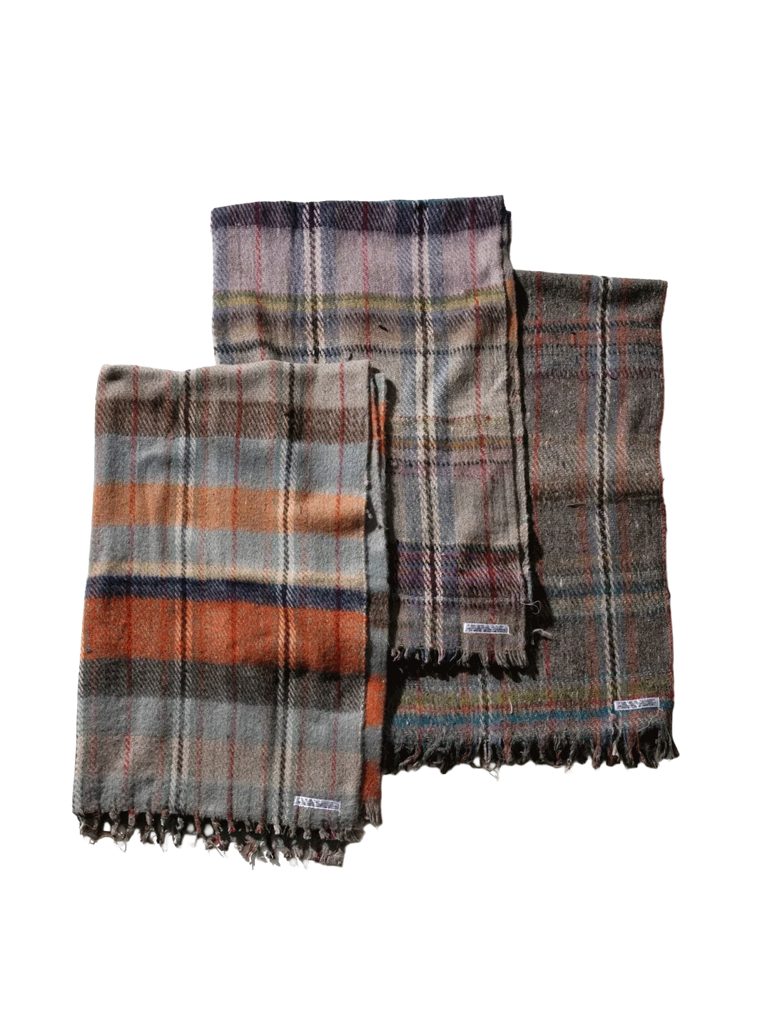 Three Puebco Recycled Wool Mix Blankets in assorted plaid patterns and muted colours, featuring grey, orange, purple and brown tones with fringed edges | Twentyseven Toronto