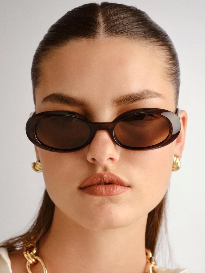 Model wearing Le Specs Work It oval sunglasses in Cocoa with brown lenses | Twentyseven Toronto