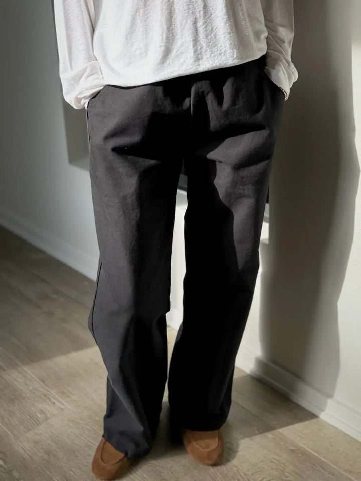 Person wearing a white long sleeve shirt and dark 'Work Pants' in Black from Le Bon Shoppe standing against a plain wall | Twentyseven Toronto