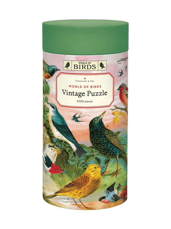 Cylindrical paper tube for the Cavallini Paper & Co World of Birds 1000 Piece Puzzle with a green cap, highlighting a central title card surrounded by vintage drawings of birds | Twentyseven Toronto