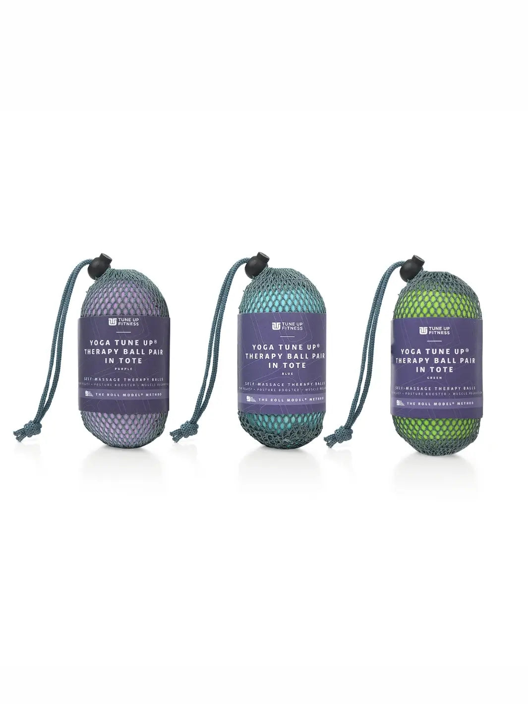 Three mesh bags holding a pair therapy balls from Tune Up Fitness, one in purple, one in blue and one in green with label on a white background | Twentyseven Toronto